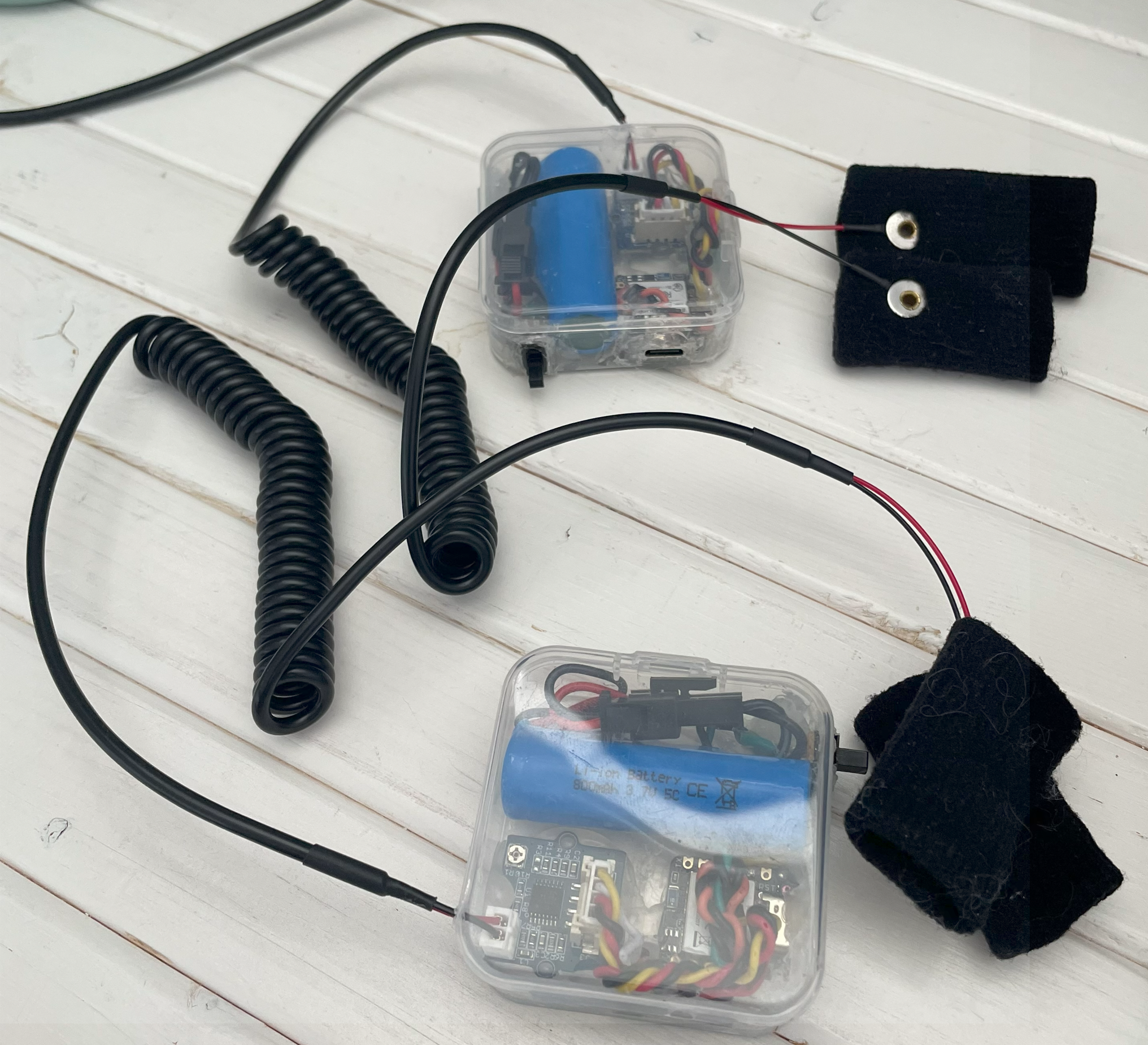 two Gardella GSR-To-Go devices in plastic cases with wired finger electrode straps